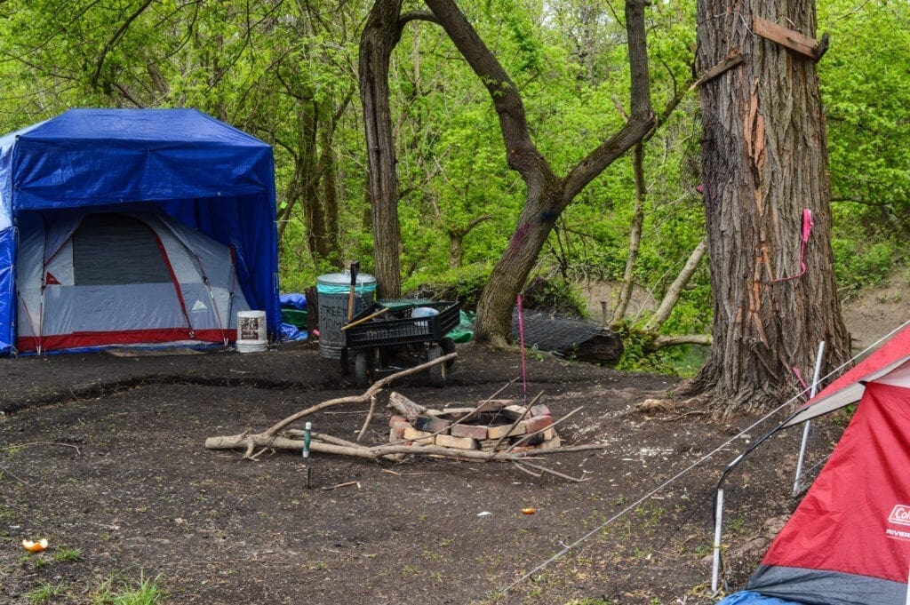 A homeless camp with a fire pit.