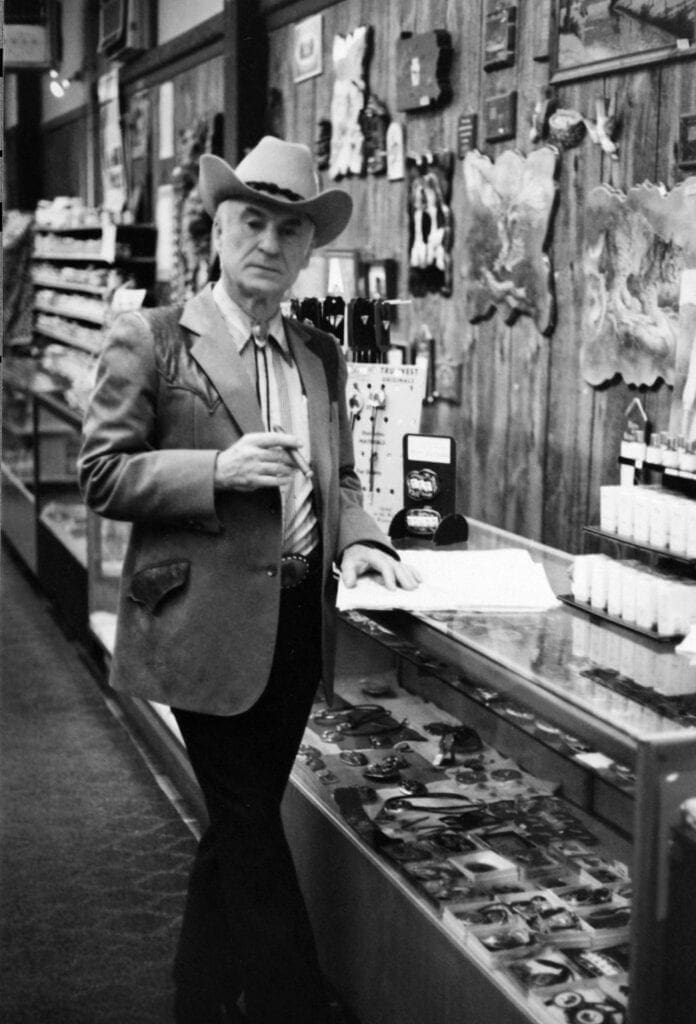 A phot of a store owner wearing a cowboy hat.