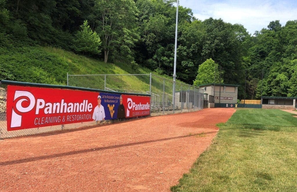 A red banner along a fence at a ballfield.