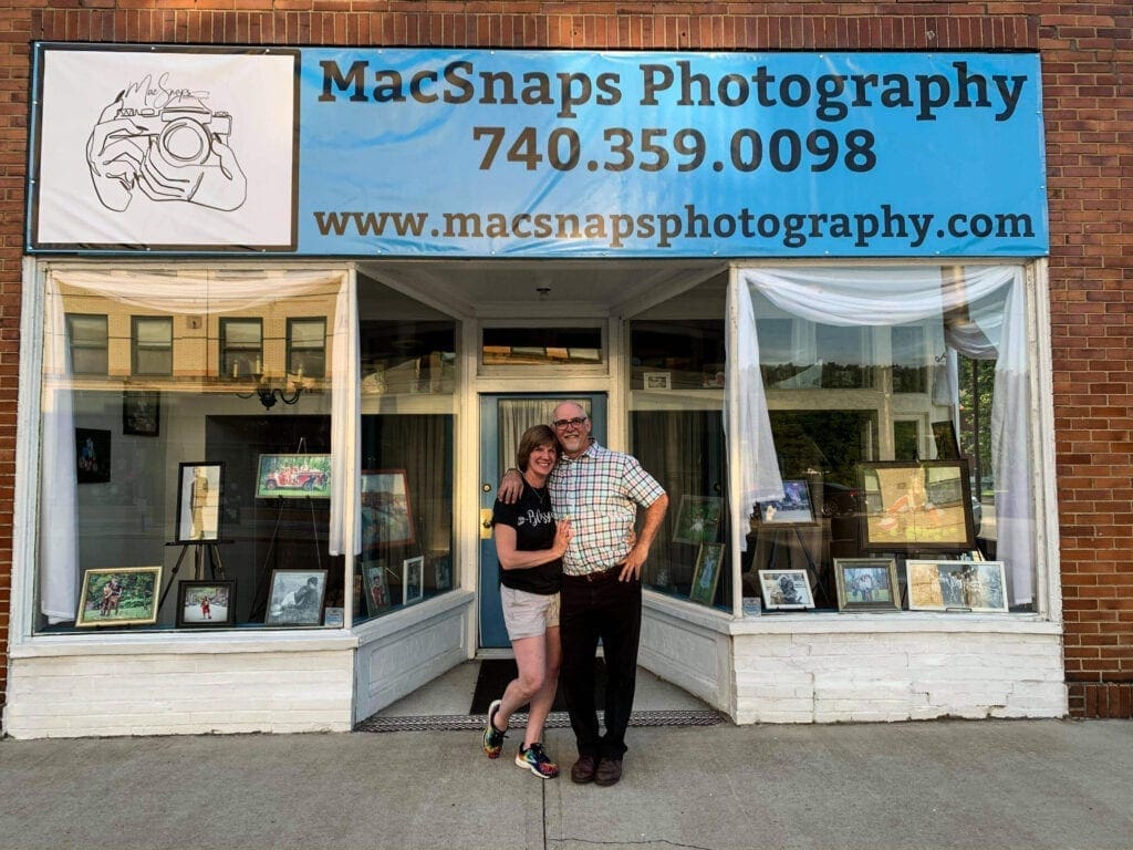 A couple standing in front of their business.