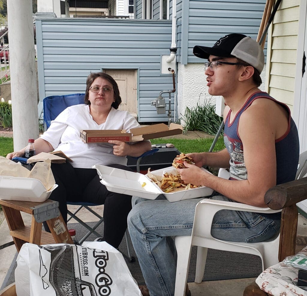 A mother and a son eating pizza.