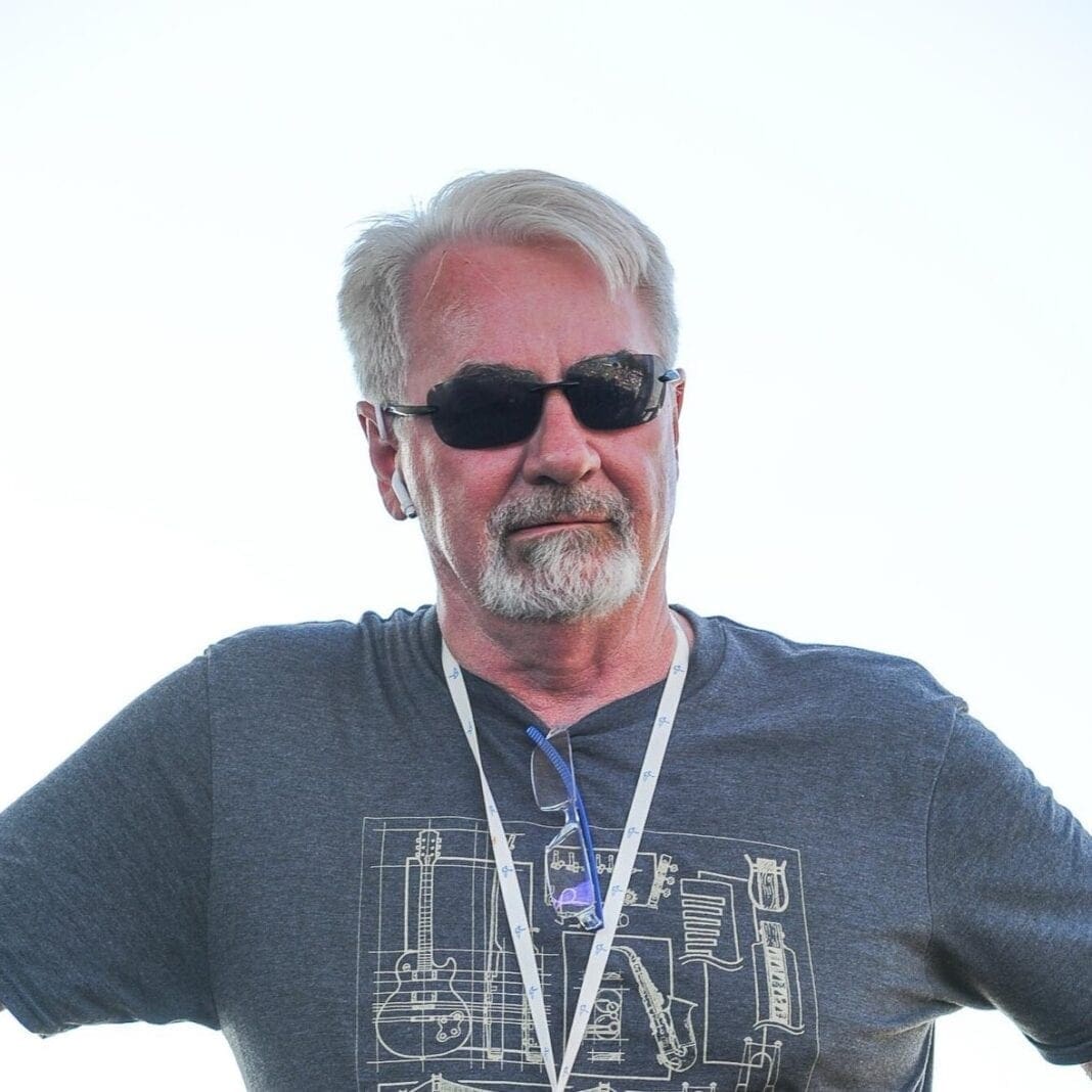 A grey-haired man wearing sunglasses.