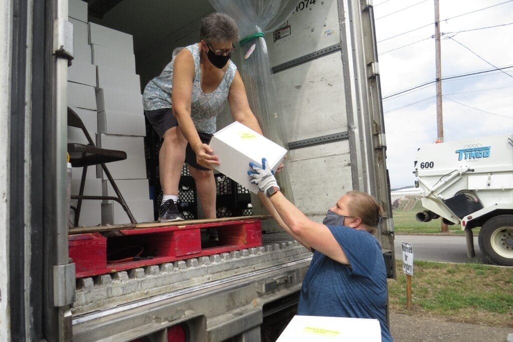 School employees emptying a truck.