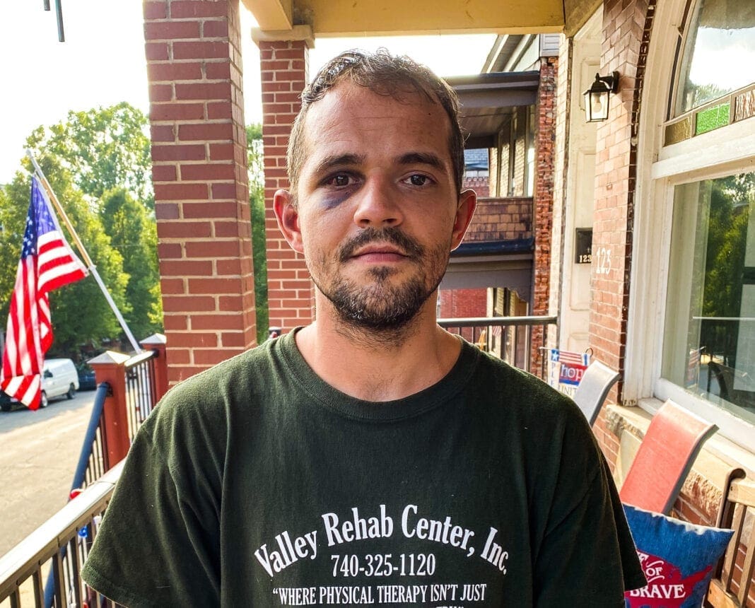 A phot of a man ina green t-shirt.