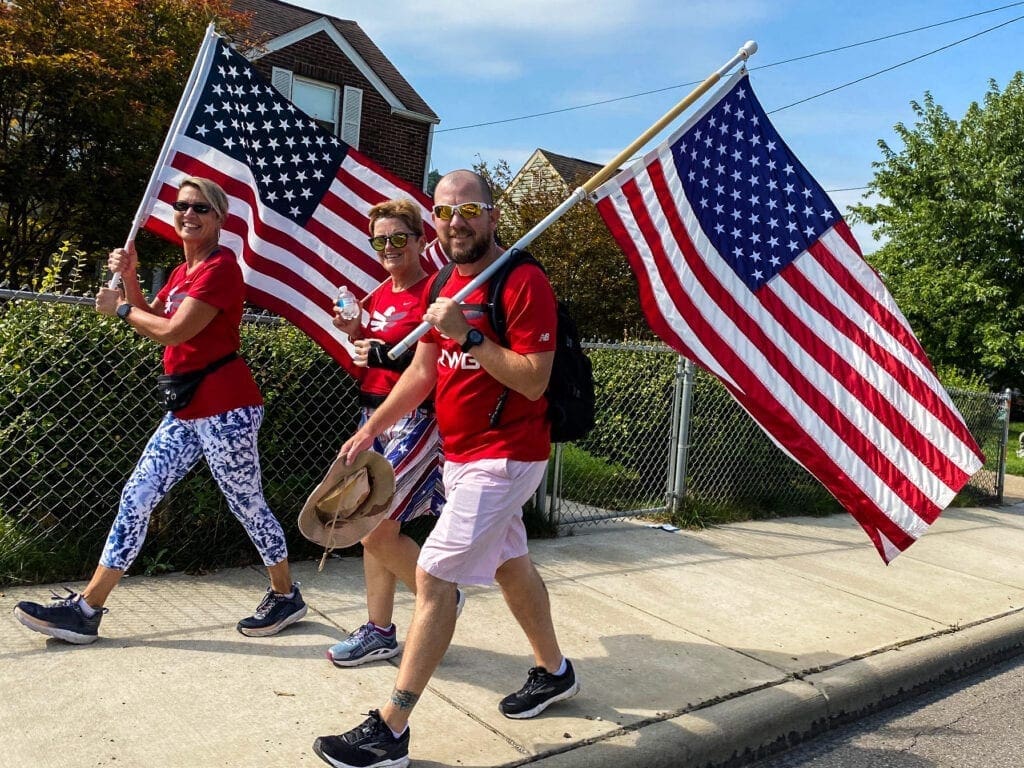 Three walkers holding flags.