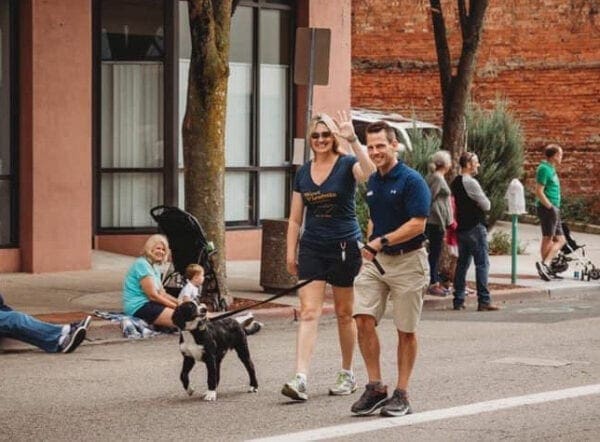 Two people walking a dog.