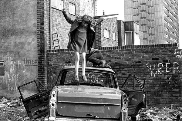 A kid jumping on a car.