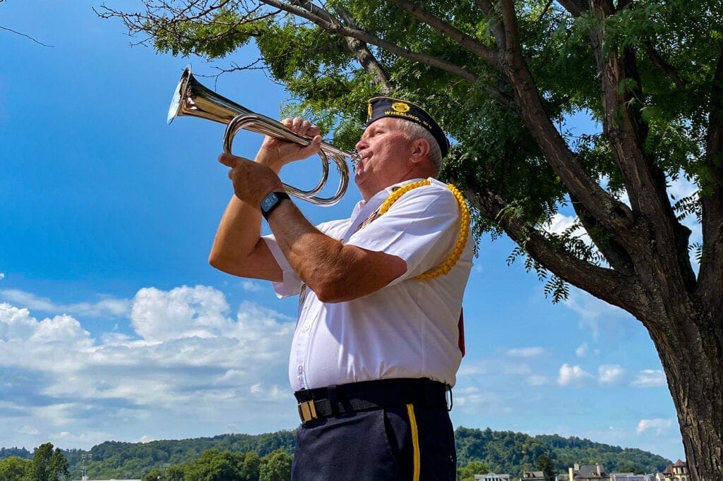 A color guard member playing Taps.