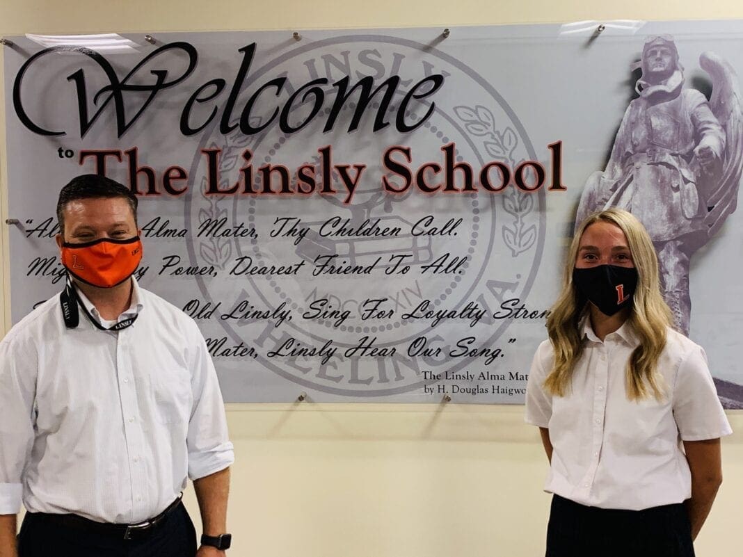 Two students in front of a sign.