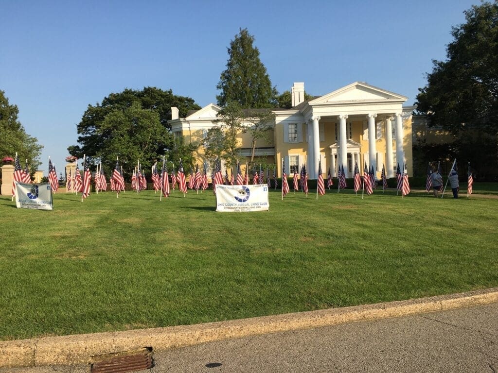 A photo of American Flags in a big yard.