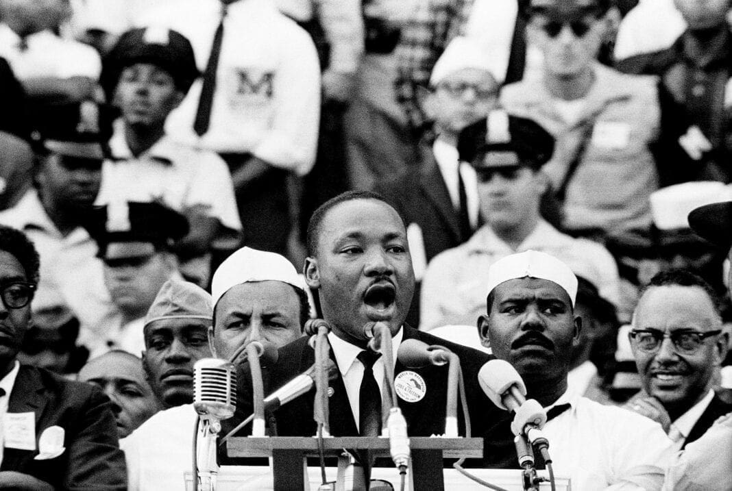 A photo of a black man giving a speech.