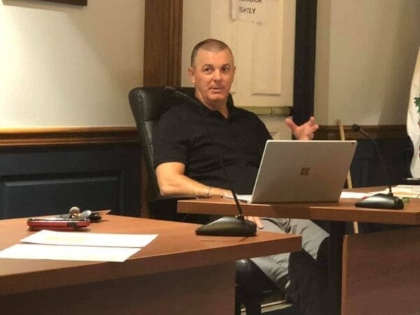 A photo of a man sitting at a desk.