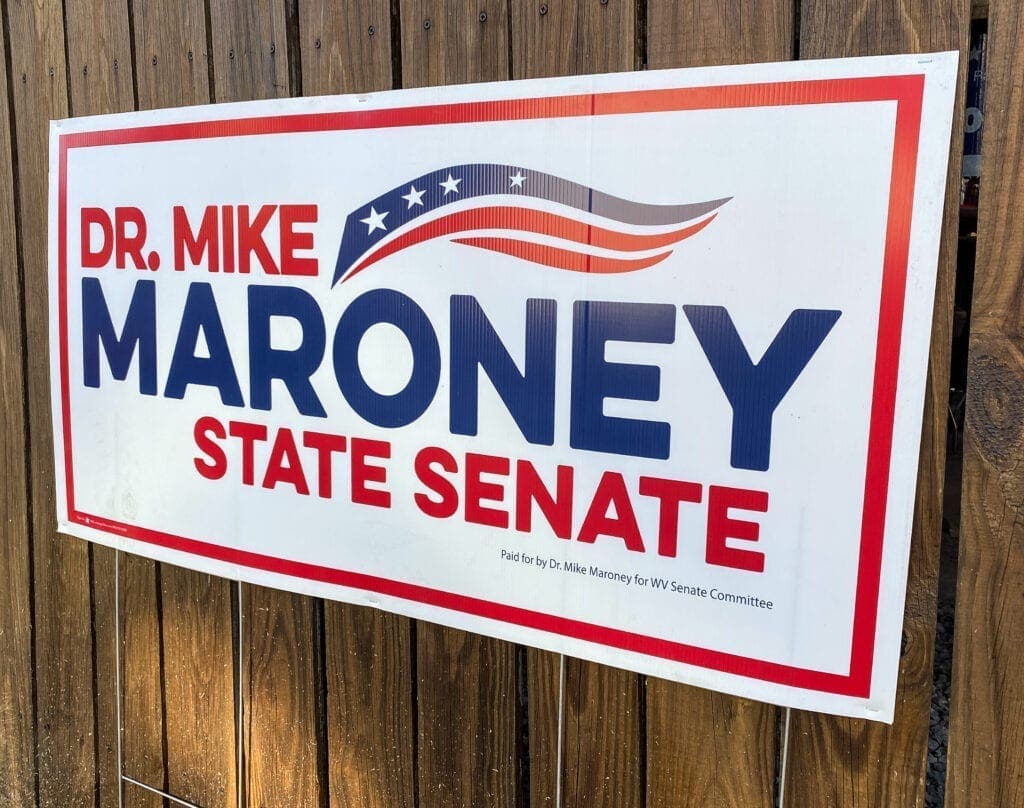 A red, white, and blue campaign sign.