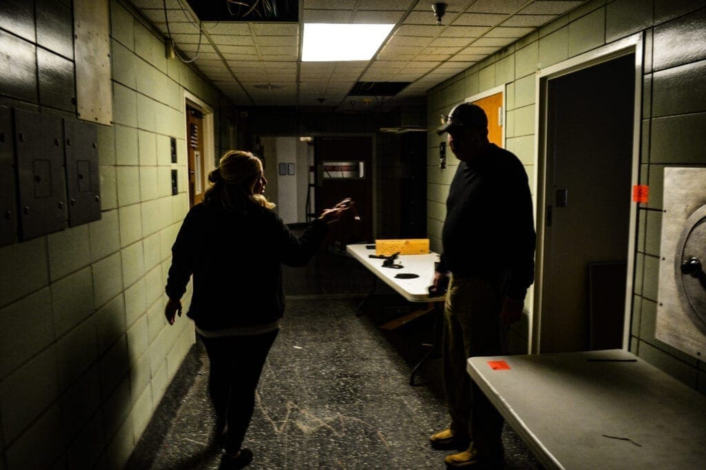 A man and a woman in a dark hallway.