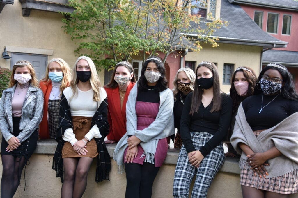 A group of a girls sitting on a wall.