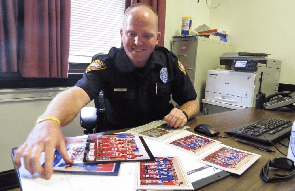 A phot of a police officer at a desk.