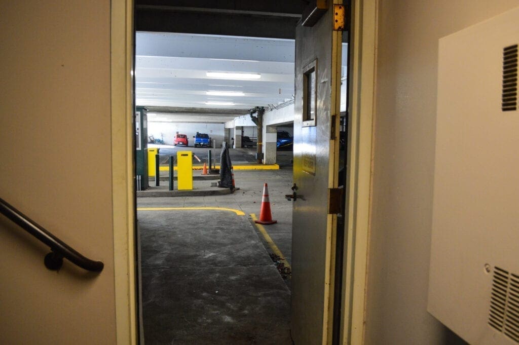 A building door that opens to a parking garage.