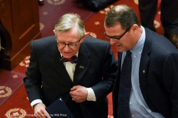 Two men speaking while standing on red carpet.