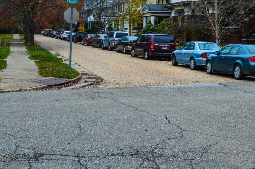 An intersection of an asphalt road and a brick road.