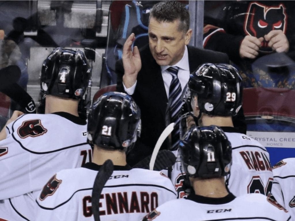 A man speaking to his hockey players.