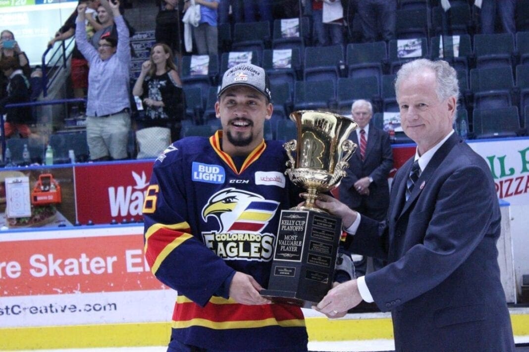 A hockey player holding a trophy.