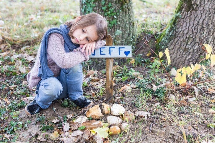 A young girl at her pet's grave.