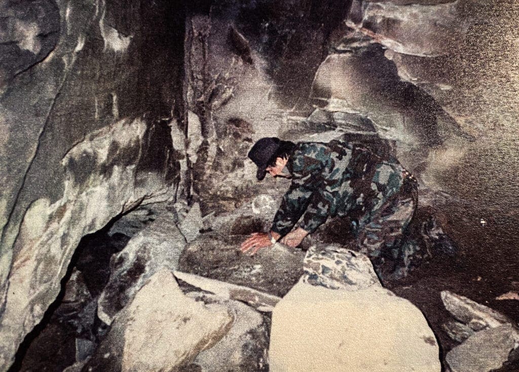 A man wearing camo in a cave.