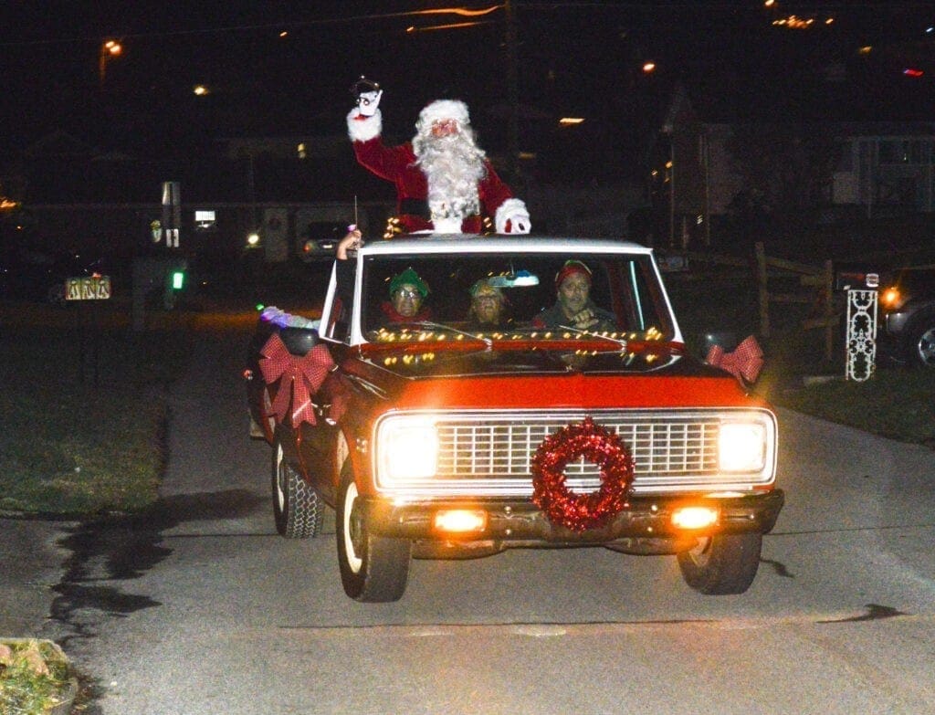 A truck with Santa in the back.