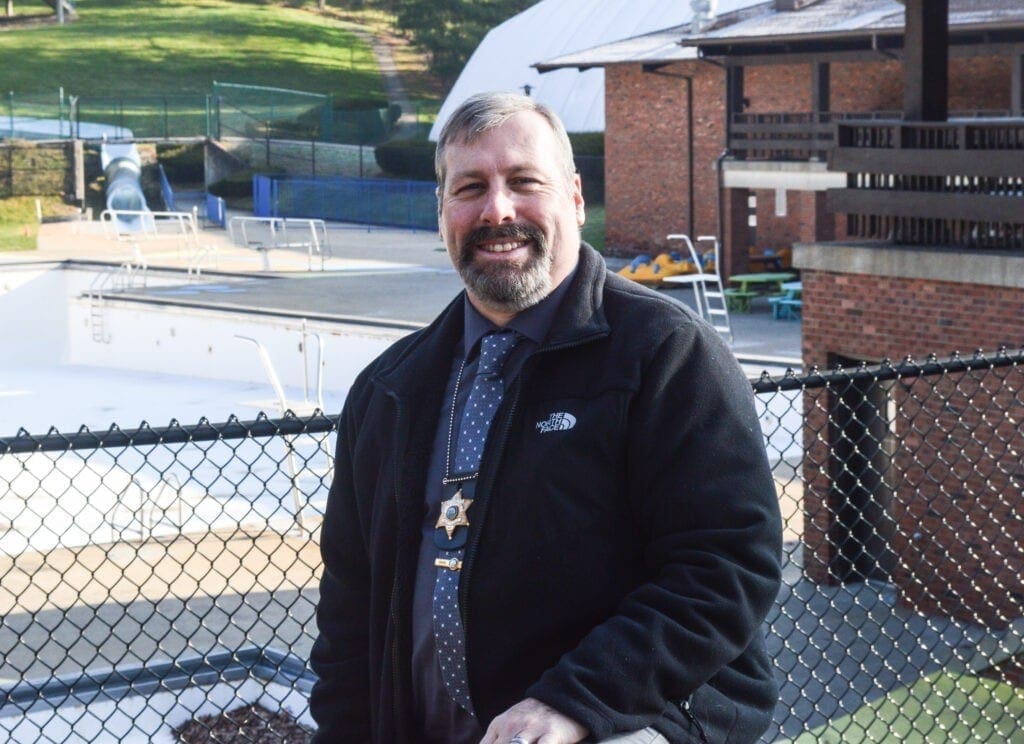 A man standing in front of an empty pool.