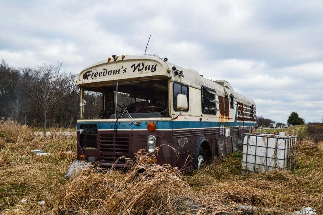 An old bus on the side of a road.