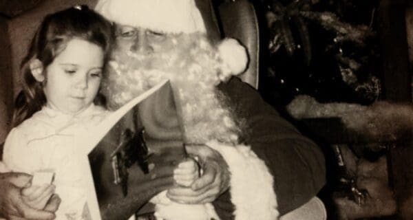 A Santa with a young girl on his lap.