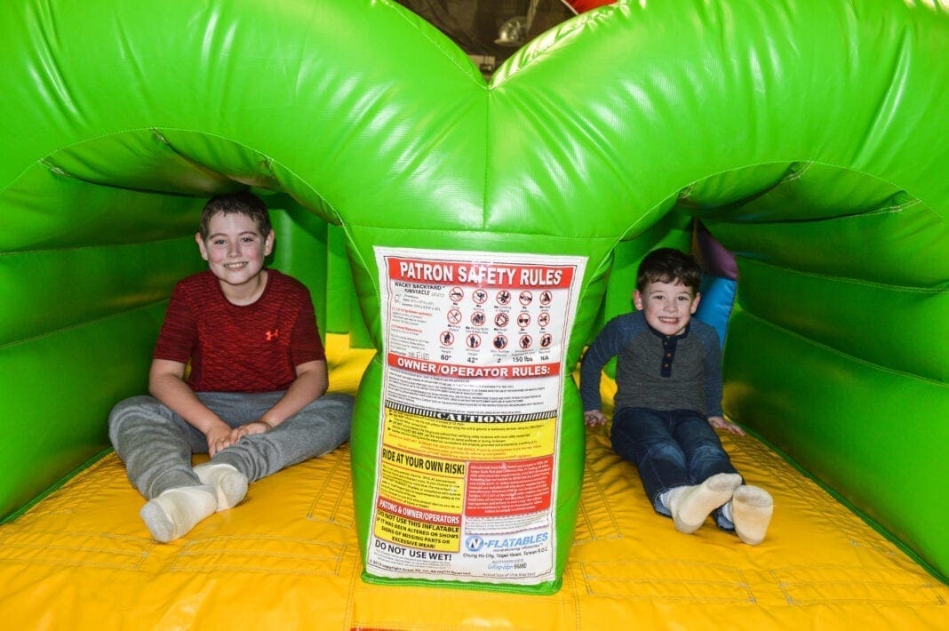 Two children in a bounce house.