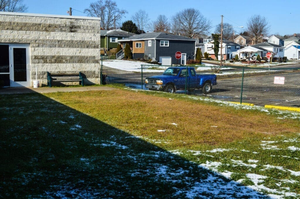 A photo of a side yard in the winter.