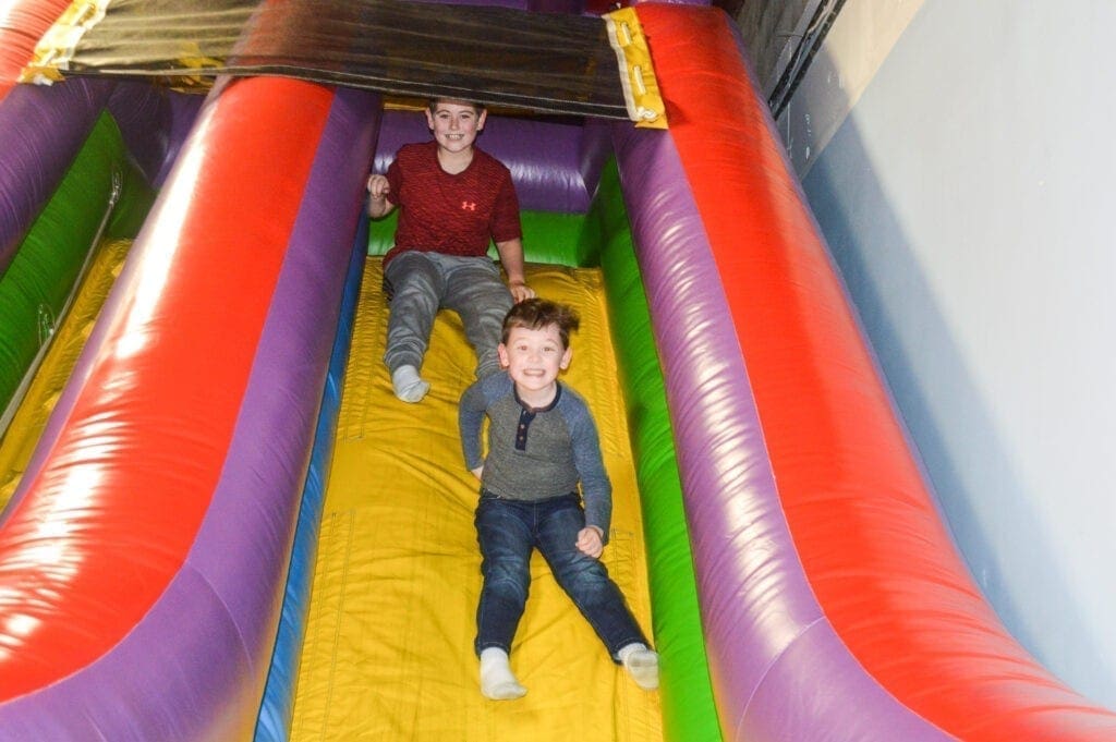 Children sliding on a inflated slide.