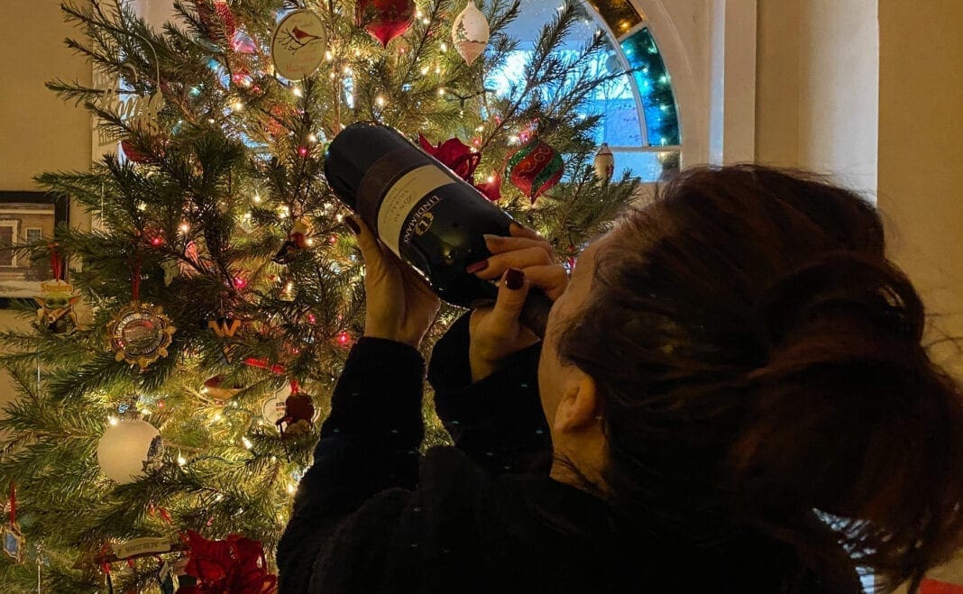 A person drinking wine from the bottle.