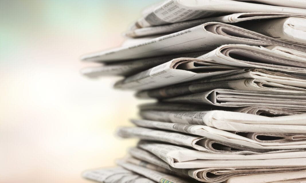 Pile of newspapers on white background.