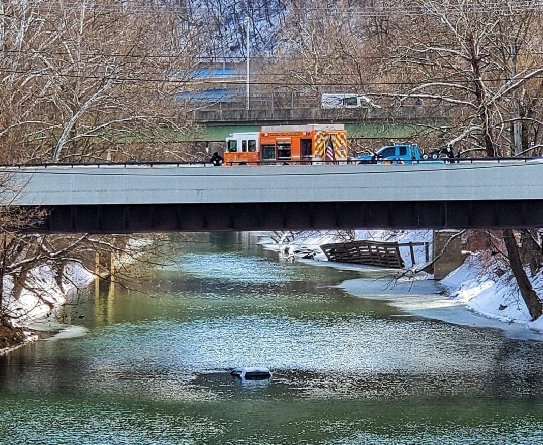 A photo of a truck in a creek.