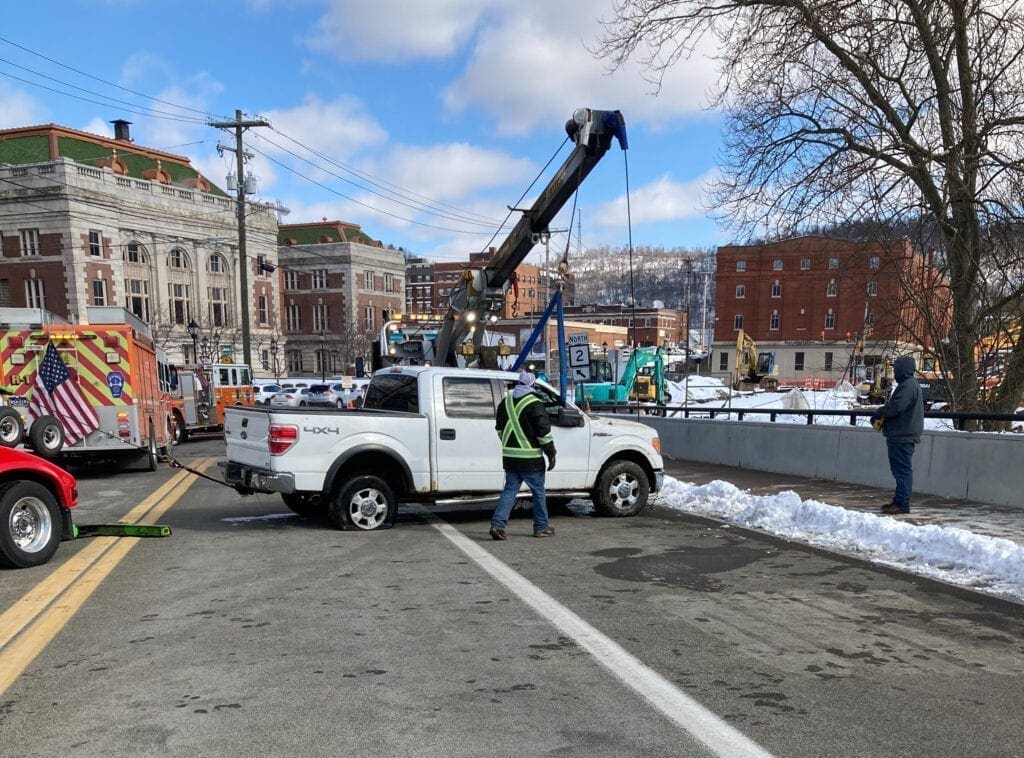 A white truck on a bridge.