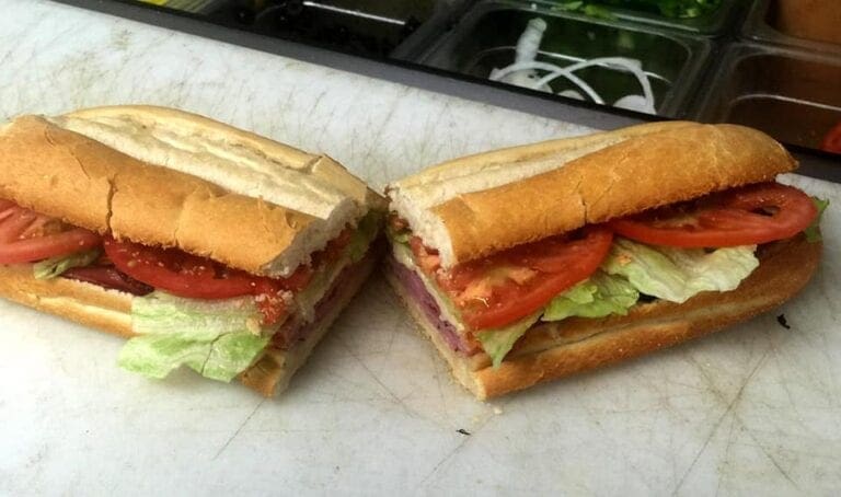 A large sub called a Hoggie is sliced in two on a sandwich board