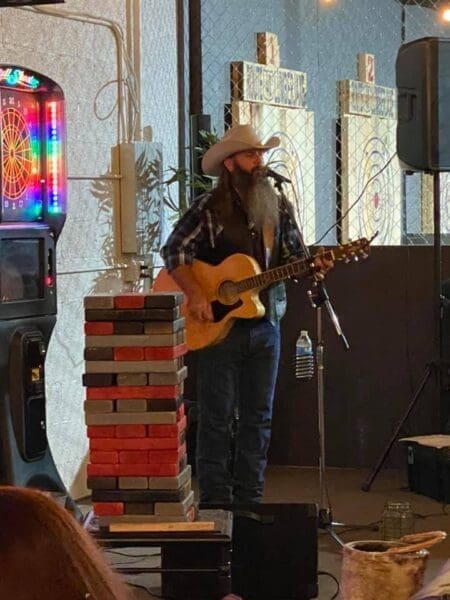 A musician sings and picks his guitar on Saturday night