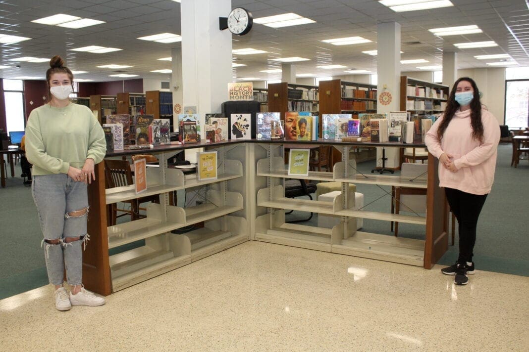 Two young ladies in a library.