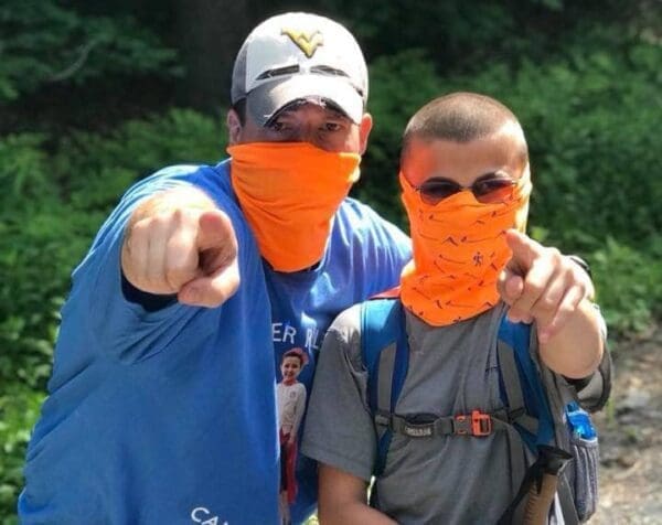 A man and child wearing orange masks.