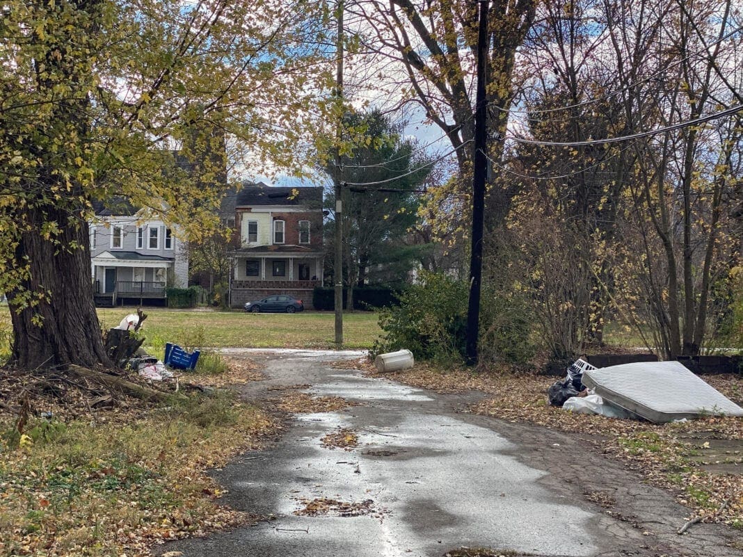 An alley with garbage along it.