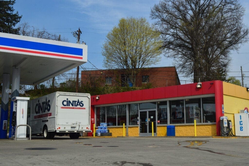 A gas station with a large truck getting gas.