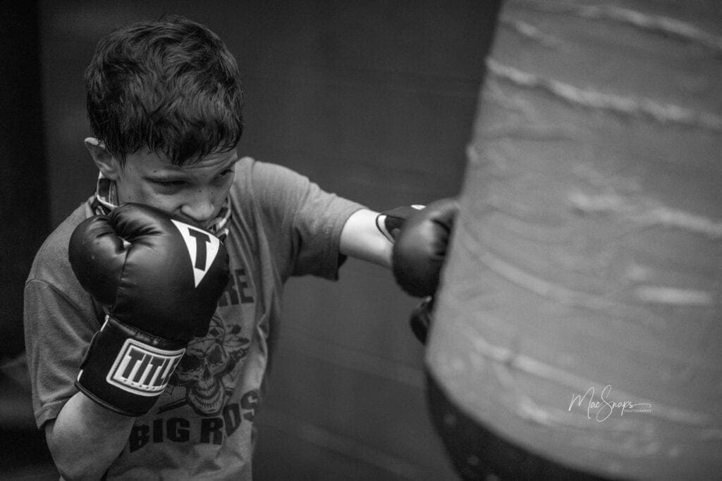 A young child hitting a heavy bag at R.L. Strength and Conditioning