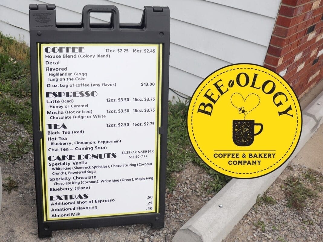 Bee-ology Coffee has a menu displayed outside the building, and viewable on the building from the drive-thru