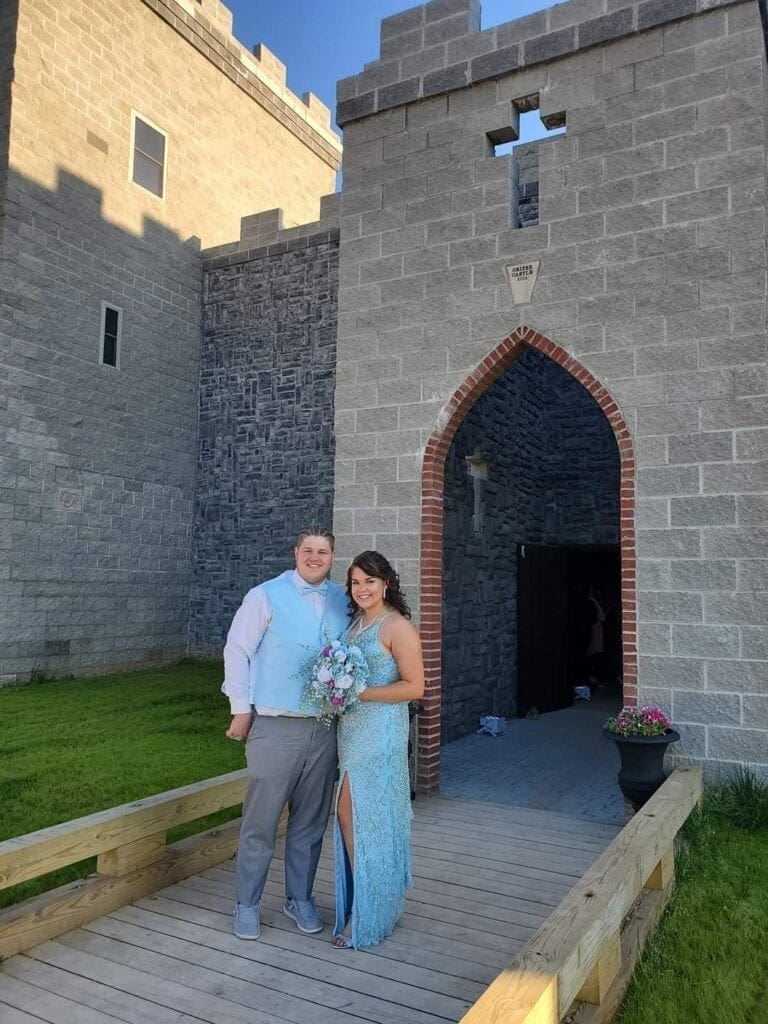 A couple stand in front of the main entrance to the keep