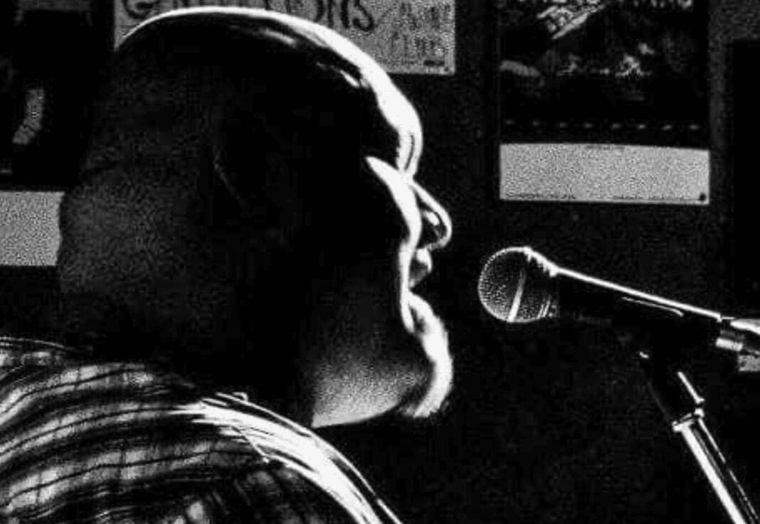 A bald man singing.