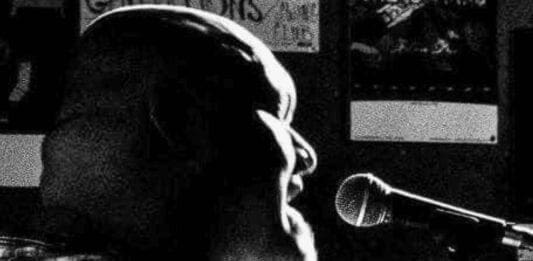 A bald man singing.