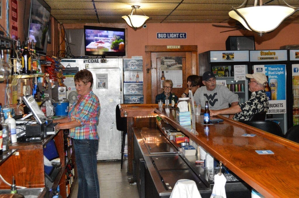 A bar with a few people sitting at it.